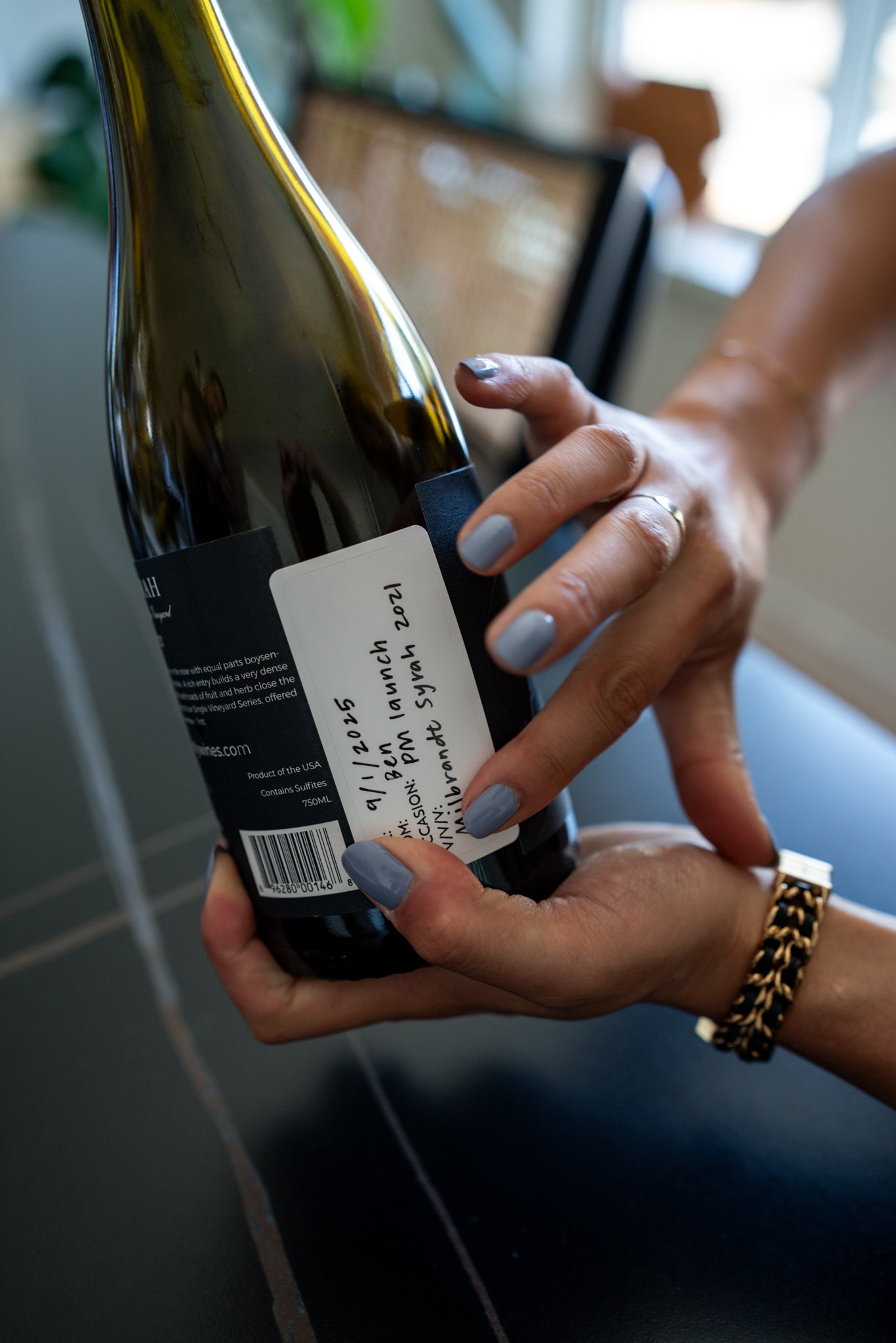 Applying the Pour Memory label to wine bottle